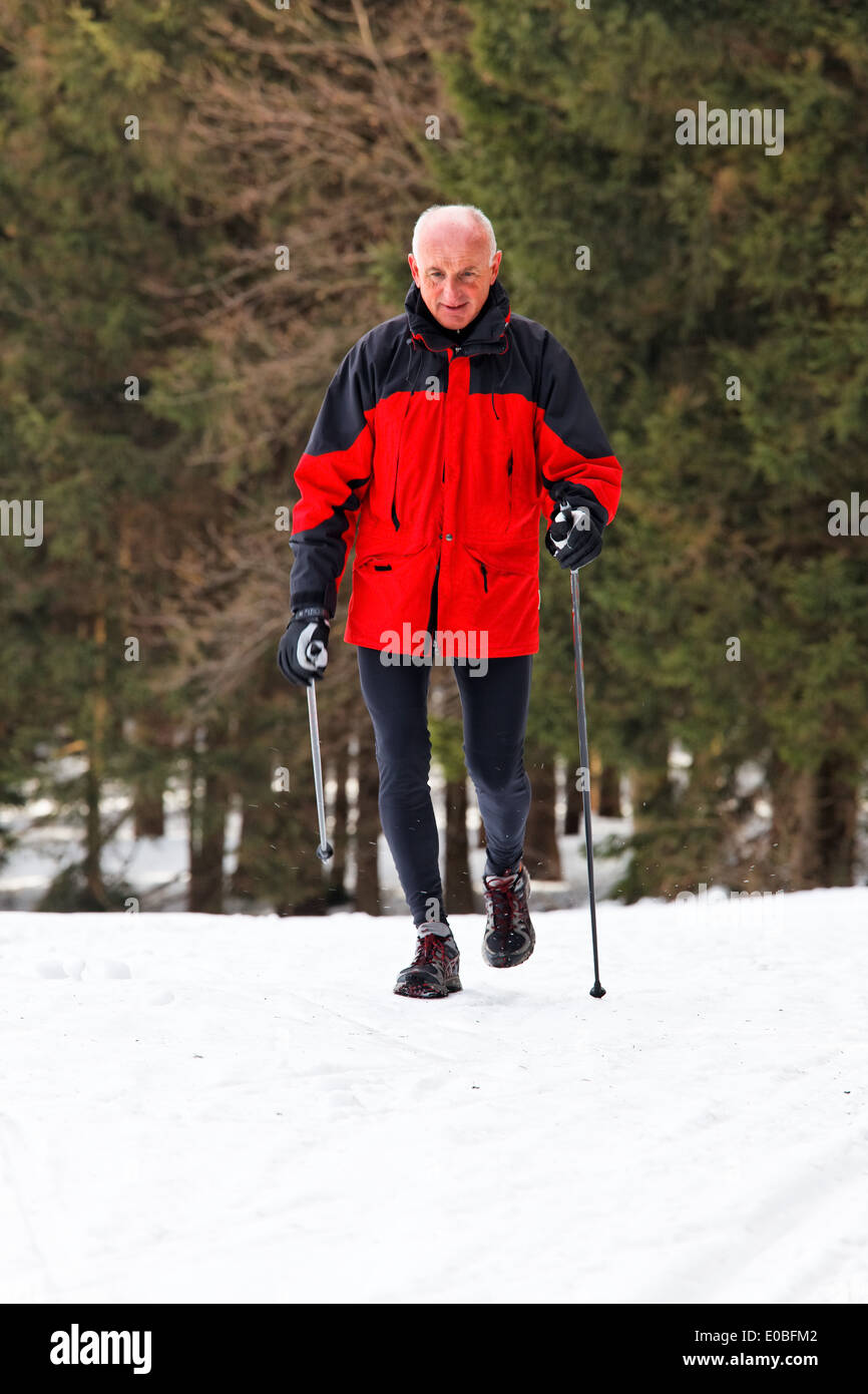 Boss in winter on snow with nordic drum, Senior im Winter auf Schnee beim nordic walken Stock Photo