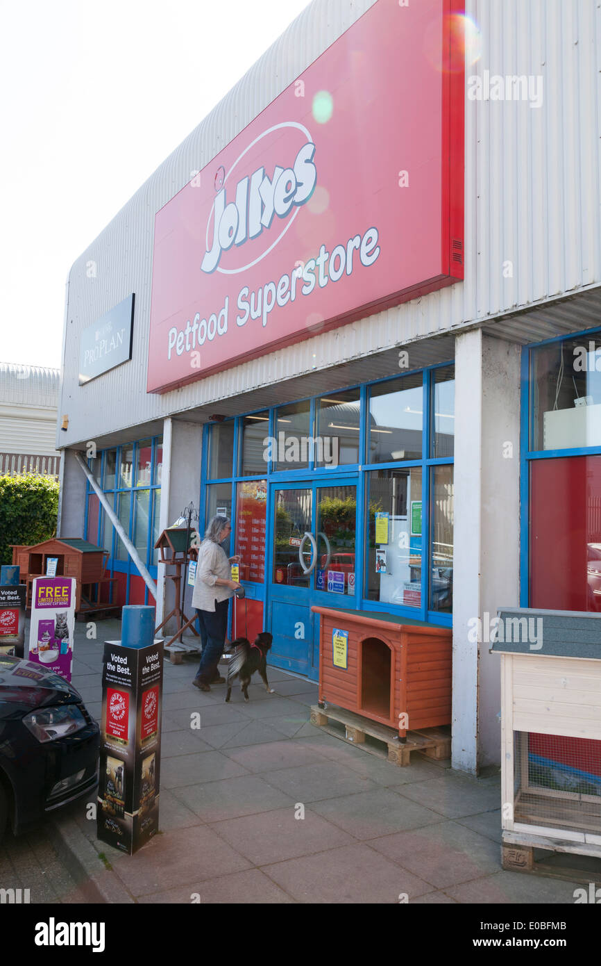 Customer with dog entering Jollyes Petfood Superstore. Stock Photo