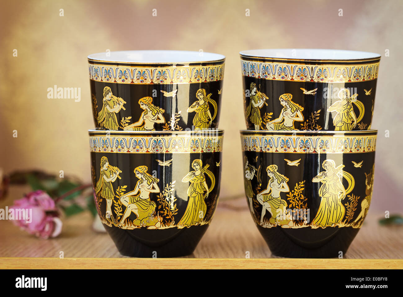 The beautiful tea cups decorated with a list with gold with the image of scenes from antique