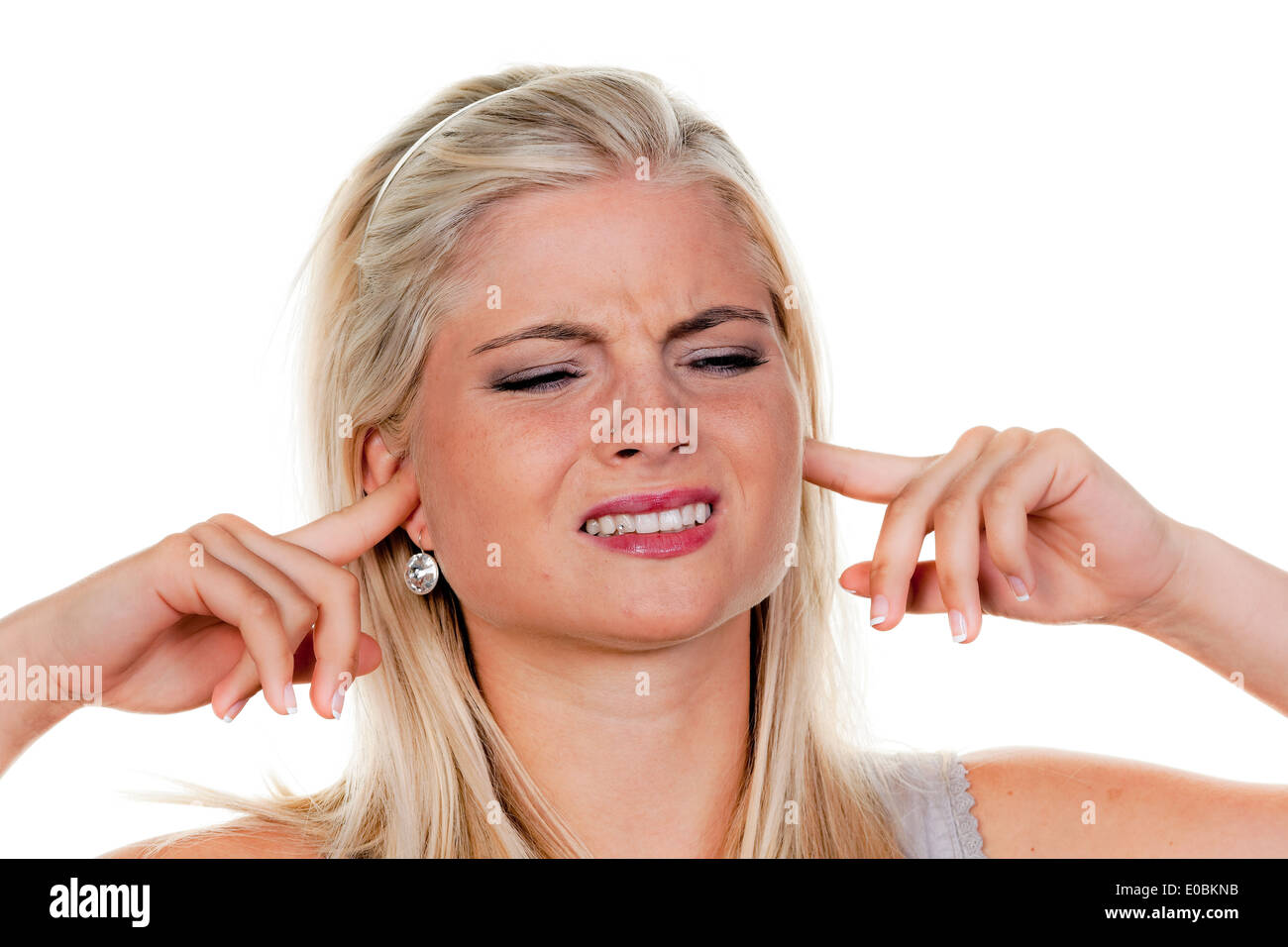 woman suffers from noise pollution, keeps closed to herself the ears Stock Photo