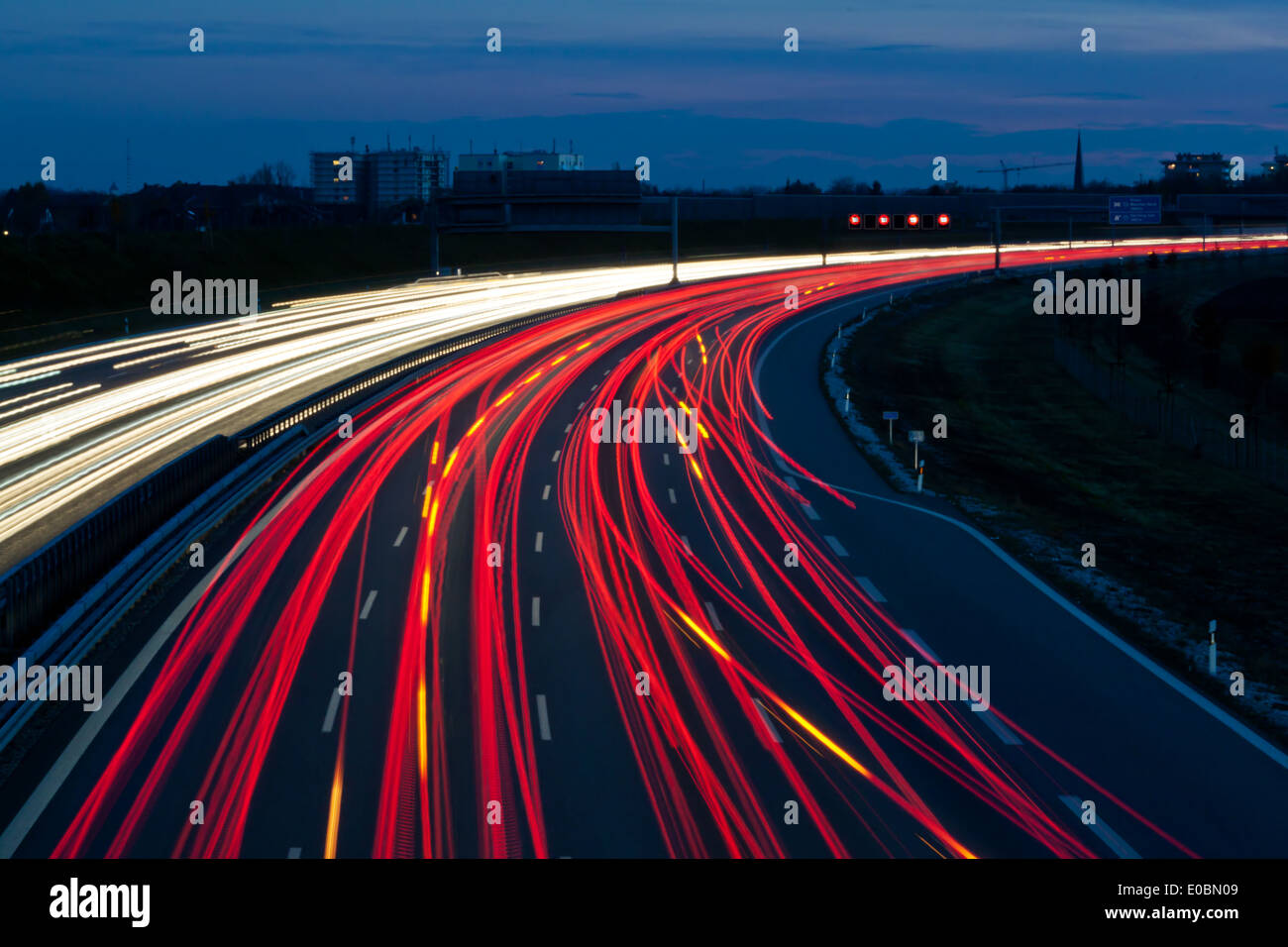 Many cars go at night on a highway and generate light tracks Stock Photo