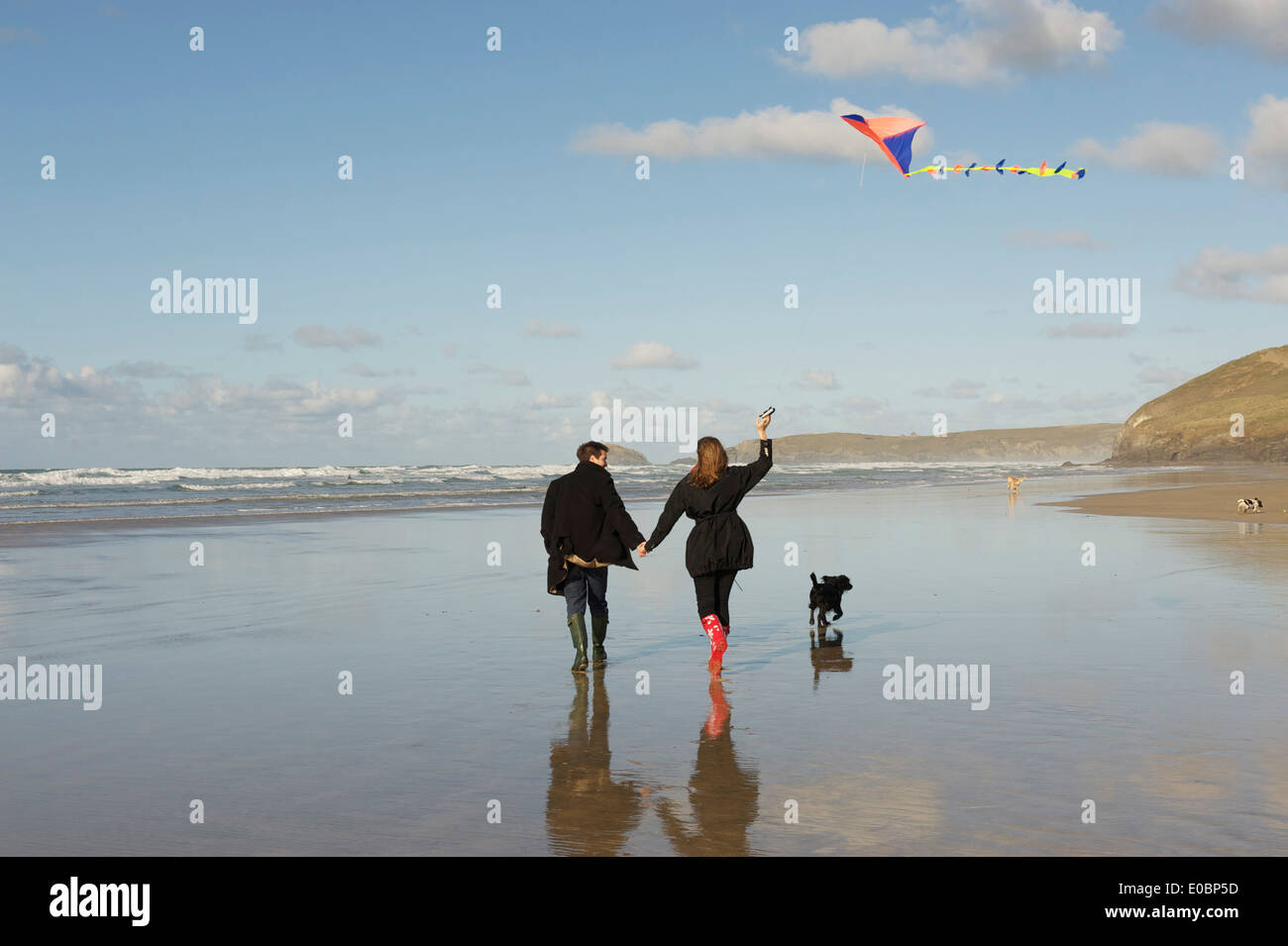 Young Romantic Couple Flying a Kite on a Beautiful Cornish Beach Stock Photo