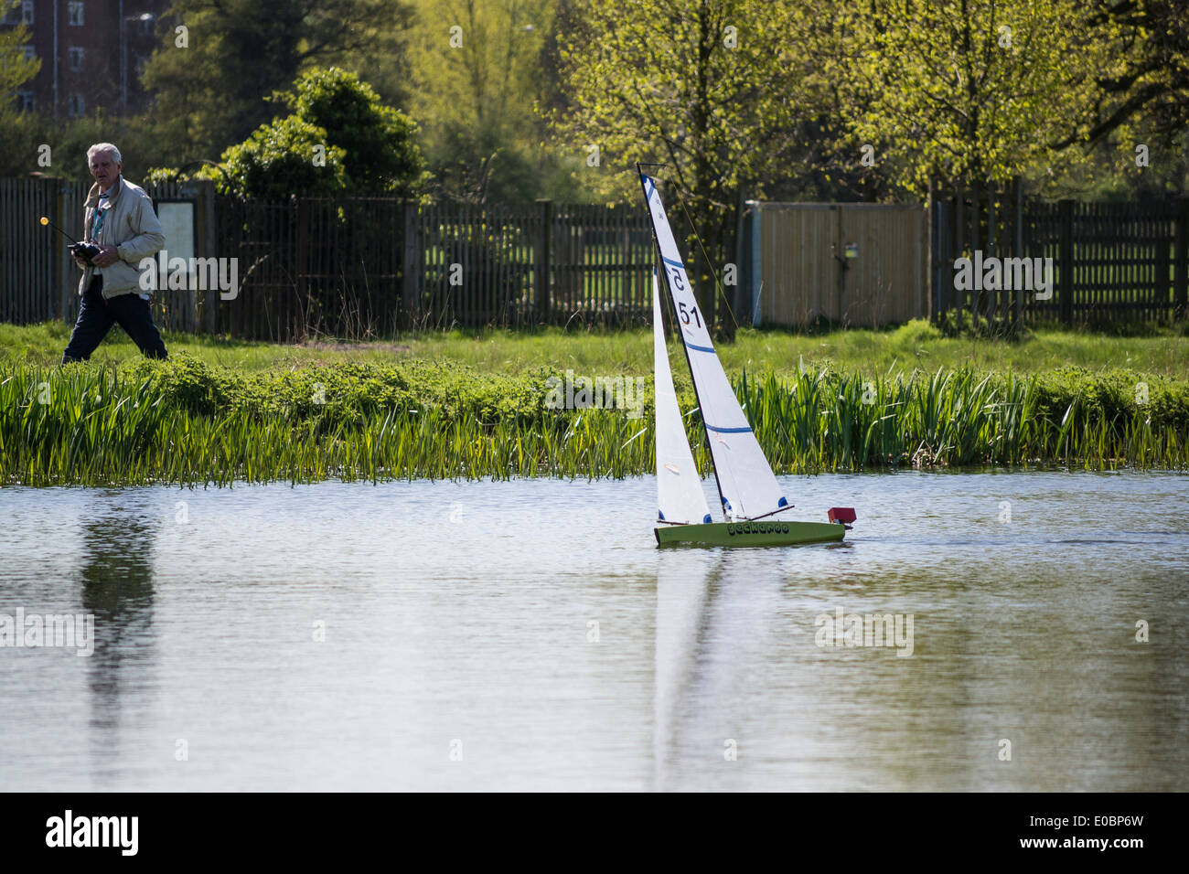 Elderly man sailing his model yacht on Rick Pond, Home Park, Kingston