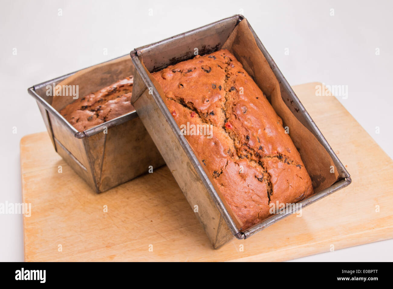 traditional fruit loaves in tins/pans ready cooked, set on a wooden board   ( 3 of 19) Stock Photo