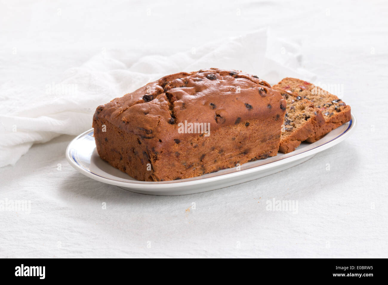 Fruit loaf /cake with slices on a white plate with a blue rim on white  (10 of 19) Stock Photo