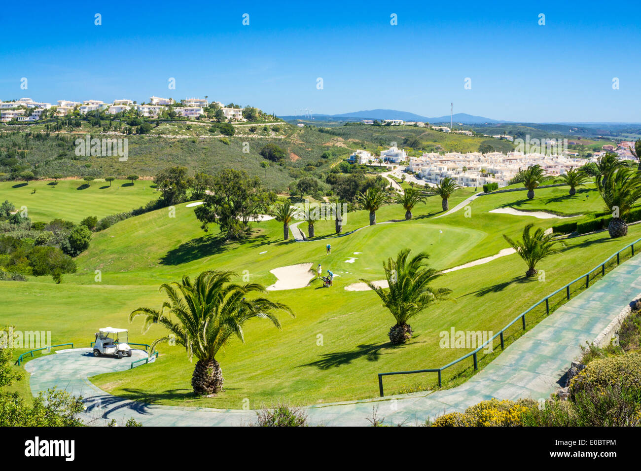 Golf buggy parked at the first hole and fairway Parque da Floresta golf course Vale do Poco Budens  near Salema Algarve Portugal Stock Photo