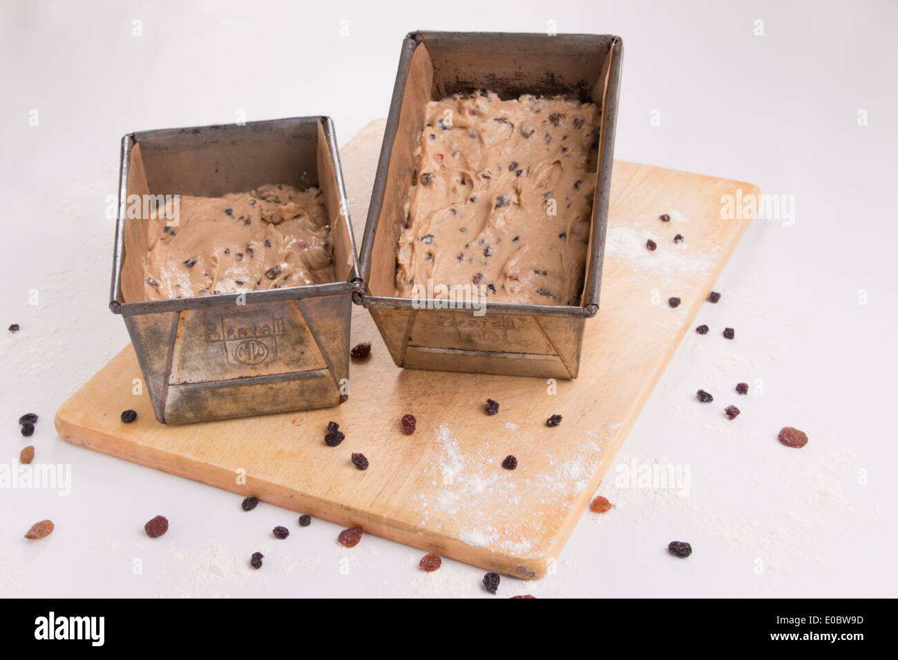 f traditional fruit loaves in tins/pans ready to cook/bake set on a wooden board with dried fruit scatter ( 2 of 19) Stock Photo