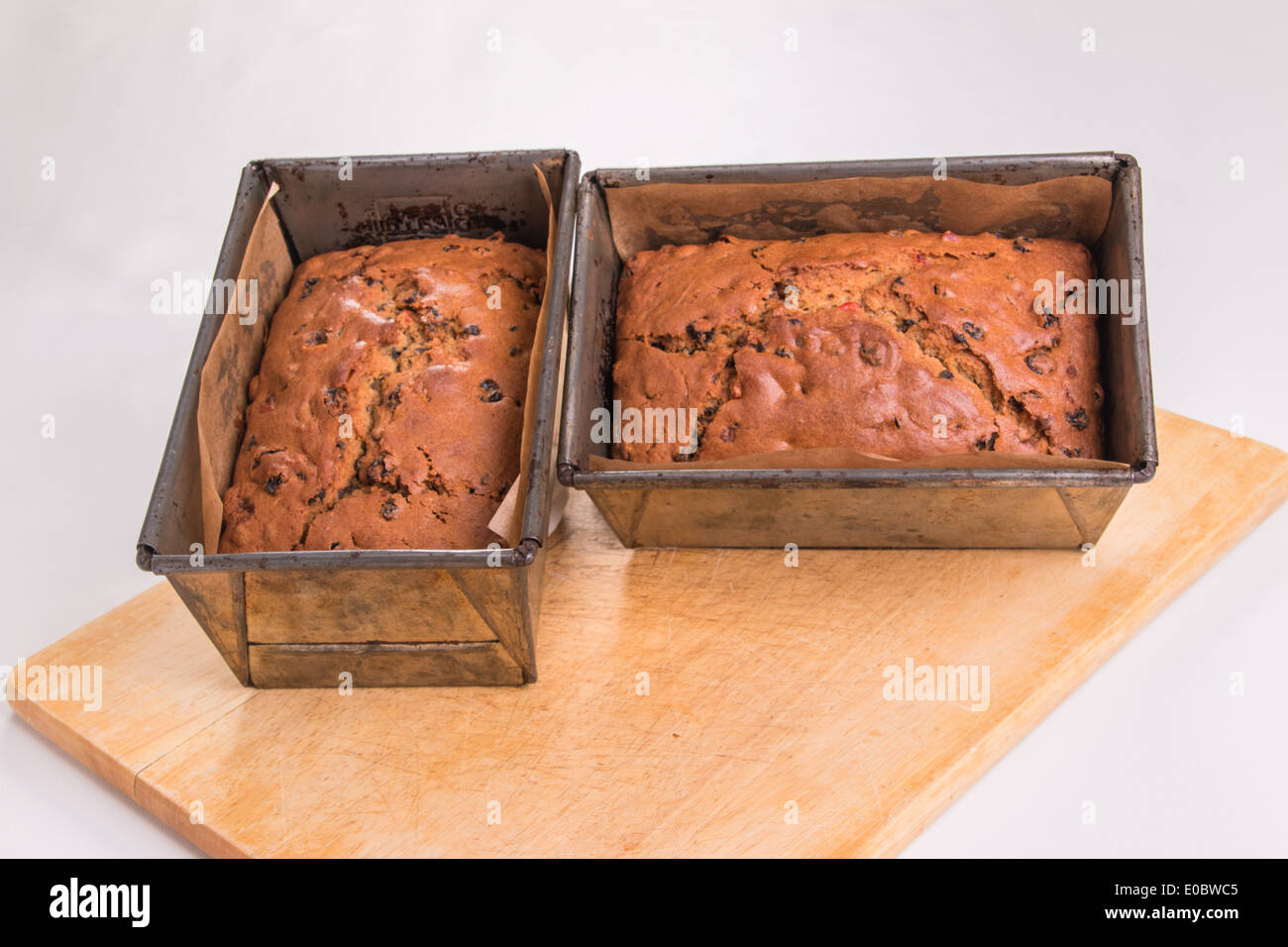 Fruit loaves in tins/pans ready cooked, set on a wooden board   ( 4 of 19) Stock Photo