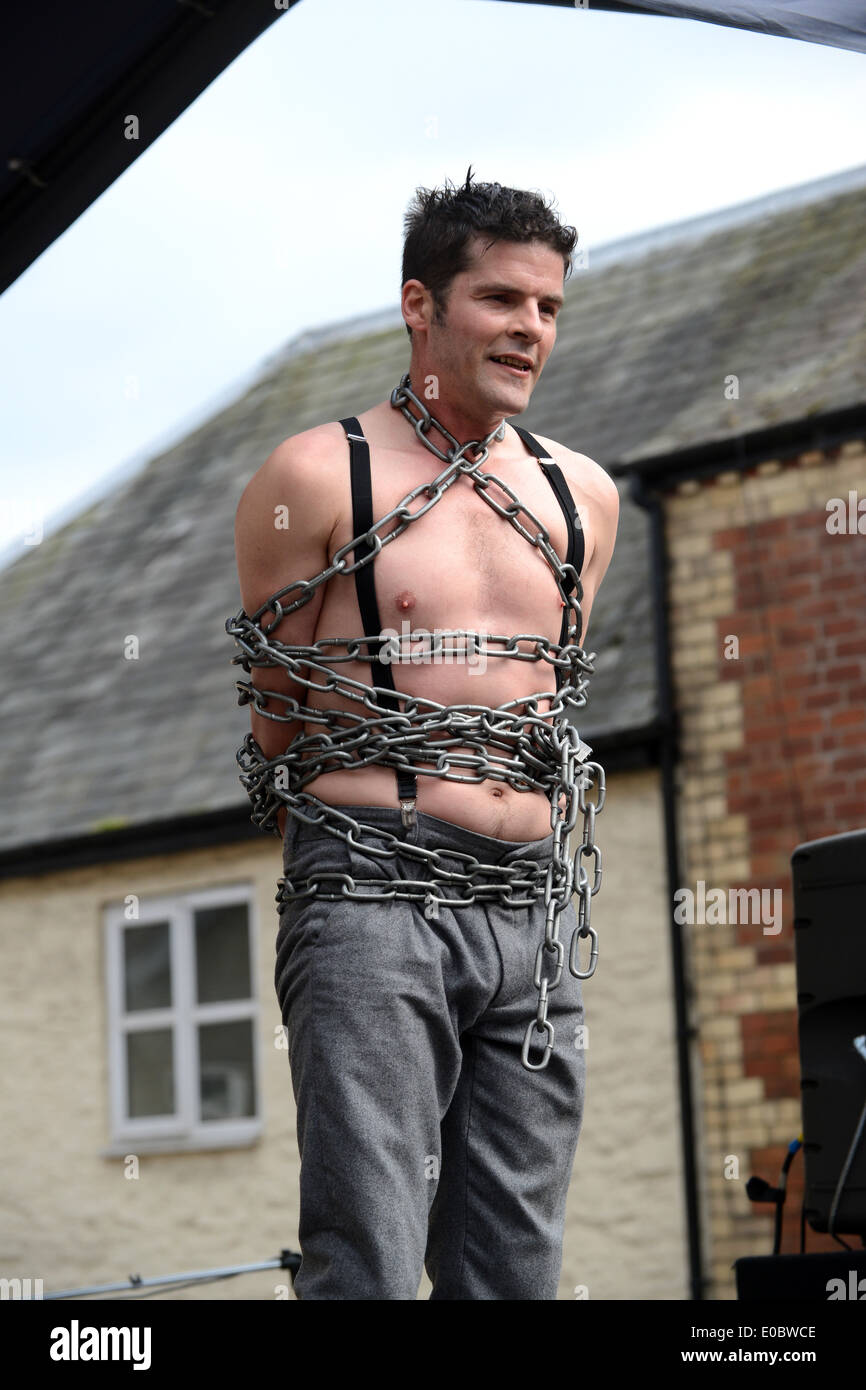 Escapologist A J James street performer and escapologist performing at The Green Man Festival at Clun in Shropshire Stock Photo