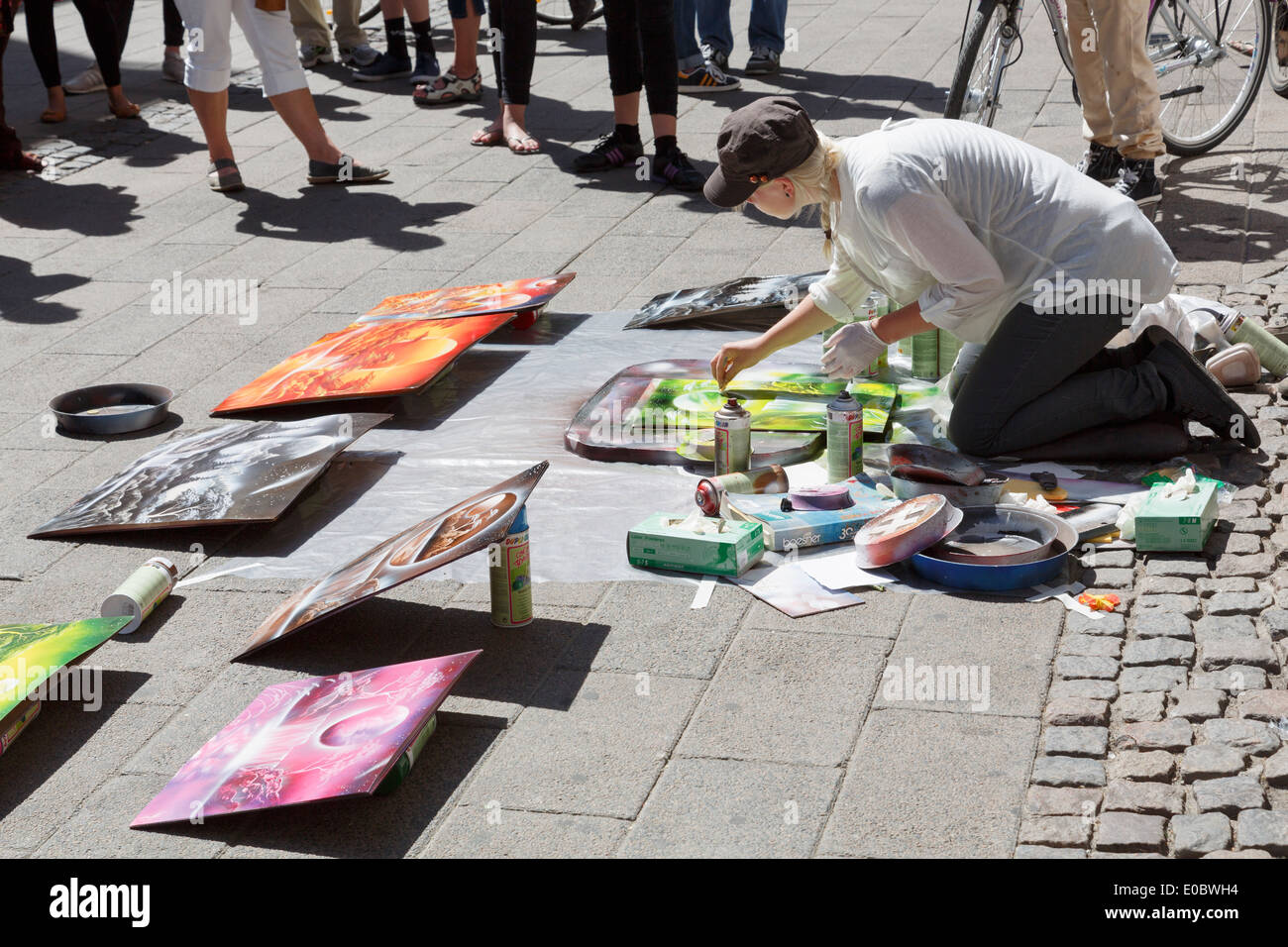 Spray paint street artist painting pictures to sell with an audience watching in Copenhagen, Denmark, Scandinavia, Europe. Stock Photo