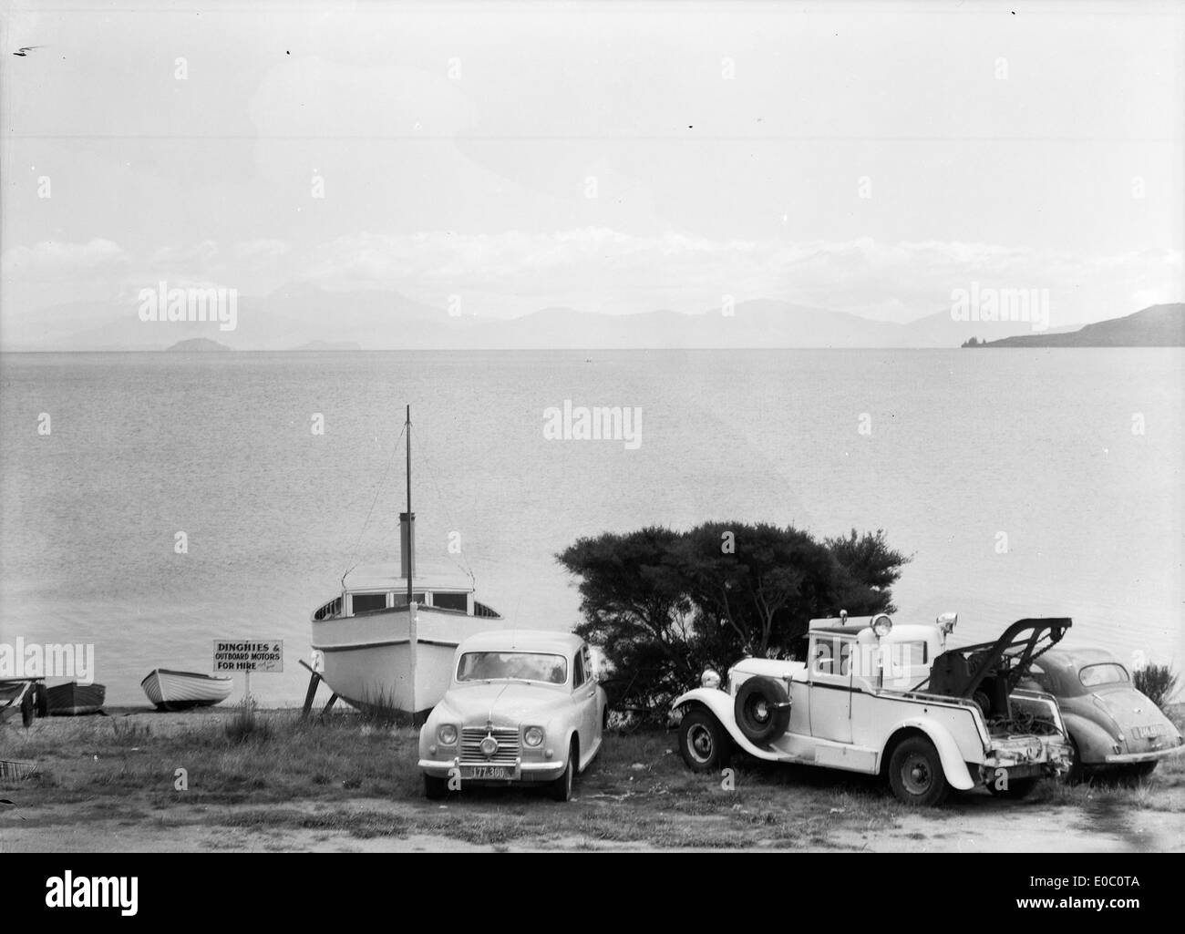Boats, cars and a tow truck, alongside Lake Taupo, ca late 1950s Stock Photo