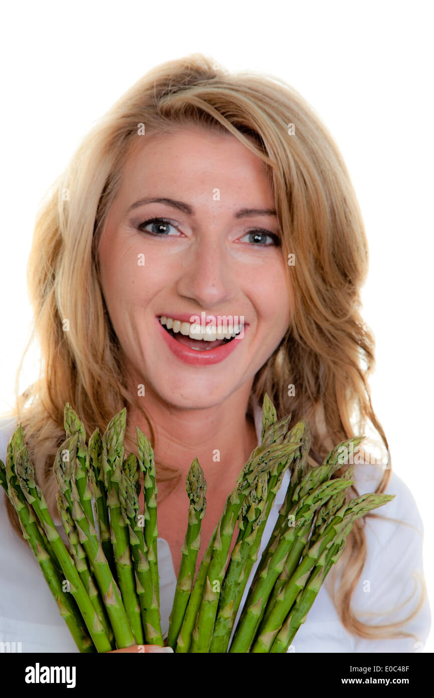 Woman with green asparagus. Before white background, Frau mit gruenem Spargel. Vor weissem Hintergrund Stock Photo