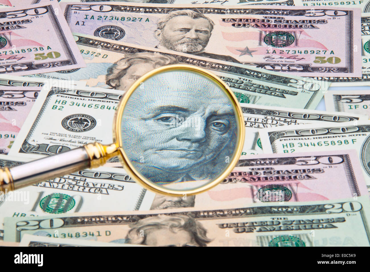A lot of dollar of bank notes by magnifying glass takes photos Stock Photo