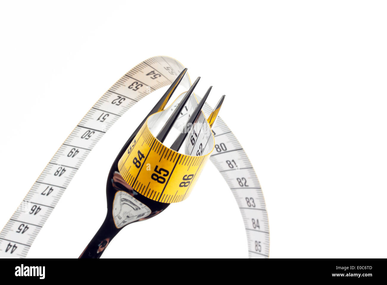 Cutlery with dimension tape. Symbol for diet and weight decrease., Besteck mit Massband. Symbol fuer Diaet und Gewichtsabnahme. Stock Photo