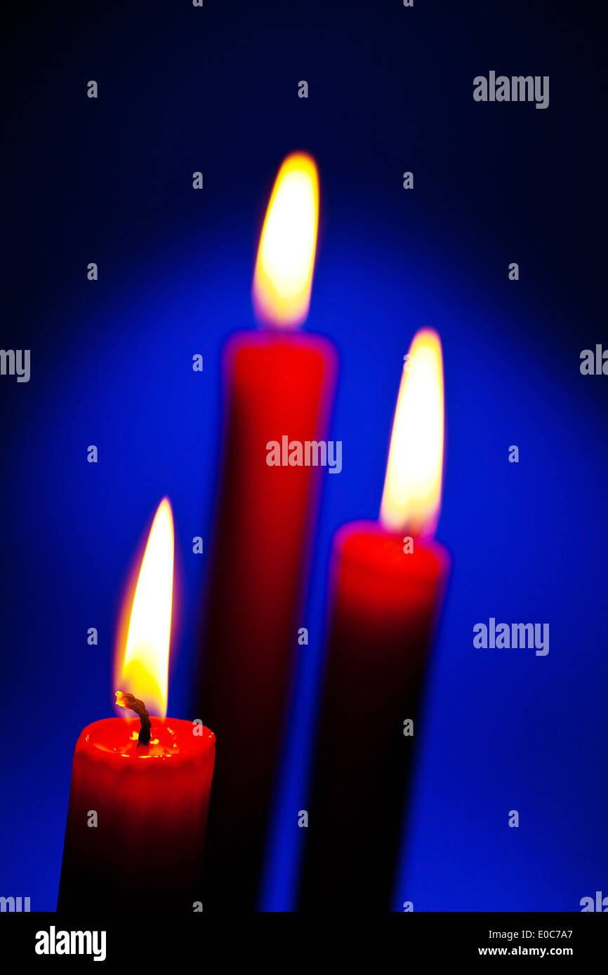 The flame of a candle brings light in the darkness, Die Flamme einer Kerze bringt Licht in die Dunkelheit Stock Photo