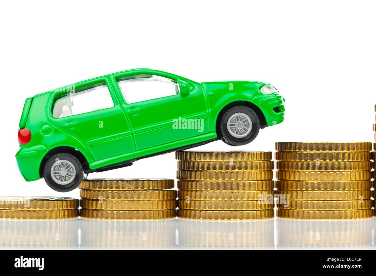 A model Car stands on coins. Rising autocosts with cost of petrol, assurance and taxes., Ein Modell Auto steht auf Muenzen. Stei Stock Photo