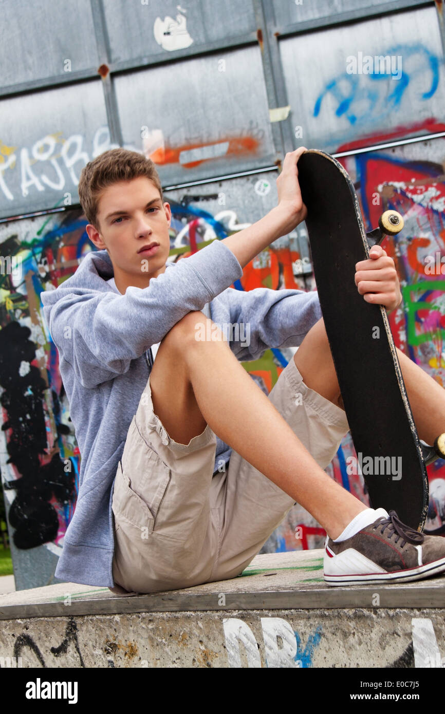 A cool looking youthful man before graffiti, Ein cool blickender Jugendlicher Mann vor Graffiti Stock Photo
