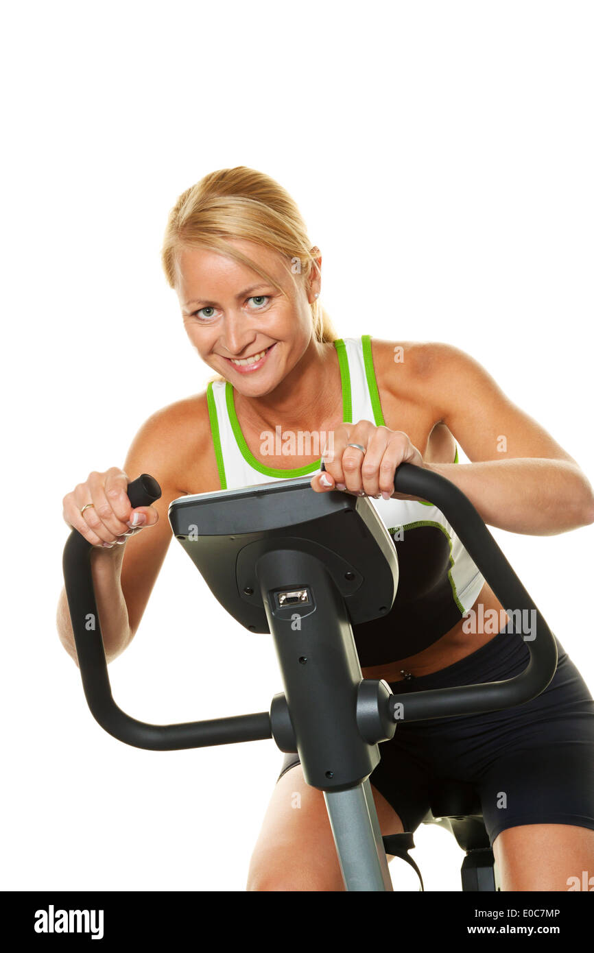 A woman trains in the fitness studio on a bicycle ergometer, Eine Frau trainiert im Fitnessstudio auf einem Fahrradergometer Stock Photo
