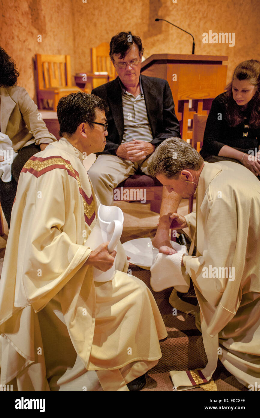 The robed pastor of St. Timothy's Catholic Church, Laguna Niguel, CA, washes the feet of parishioners on Holy Thursday mass in memory of Christ washing the feet of his disciples at the Last Supper. Note age range. Stock Photo
