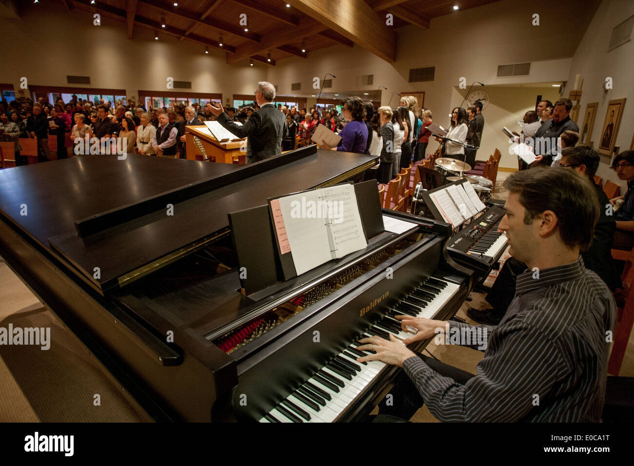 A choir and orchestra perform at a mass in St. Timothy's Catholic Church, Laguna Niguel, CA. Note choir director. Stock Photo