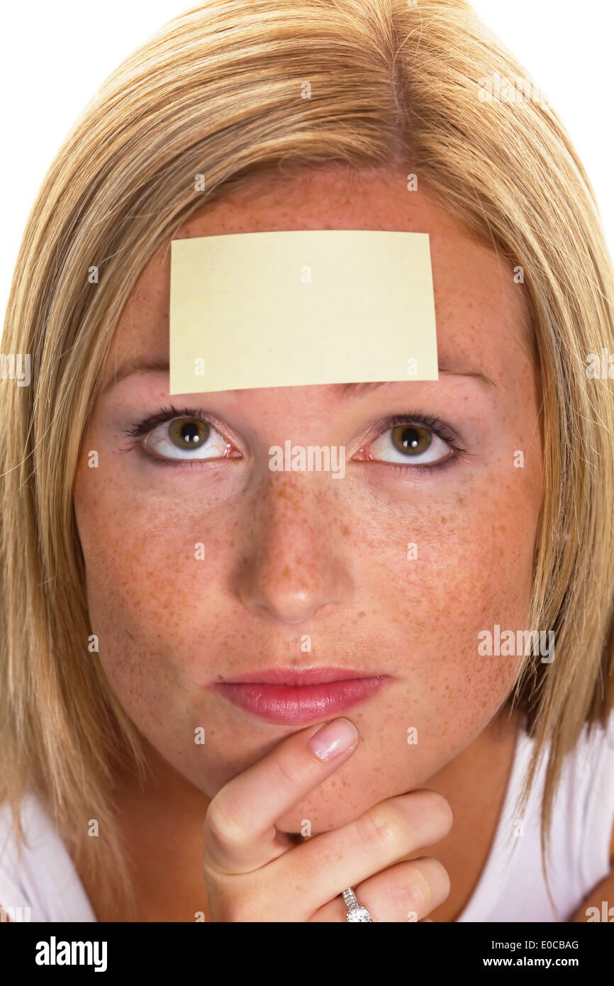 A young woman with a memorandum on the forehead, Eine junge Frau mit einem Merkzettel auf der Stirn Stock Photo