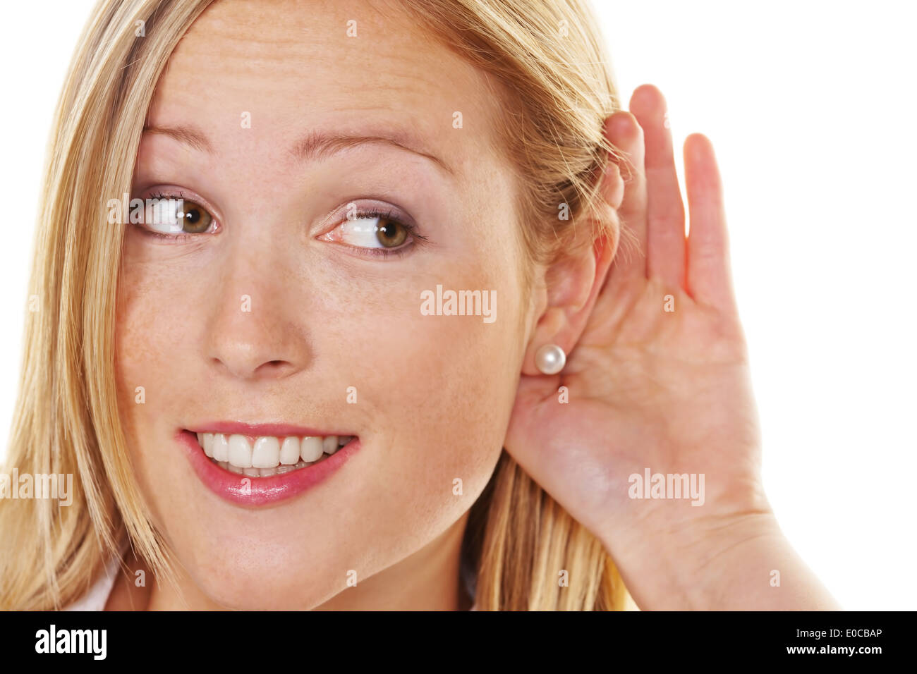 A young woman keeps with listen the hand behind the ear., Eine junge Frau haelt sich beim zuhoeren die Hand hinter das Ohr. Stock Photo