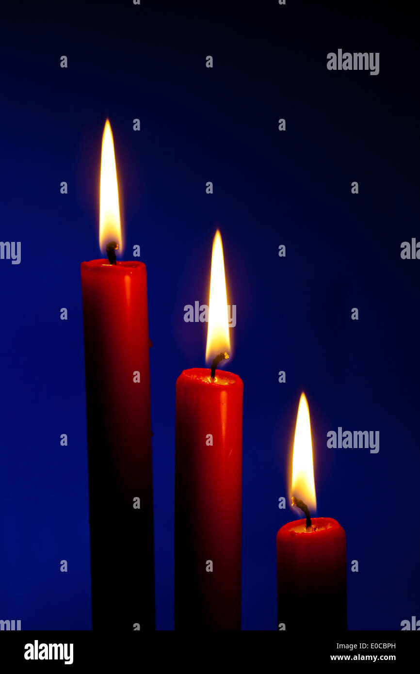 The flame of a candle brings light in the darkness, Die Flamme einer Kerze bringt Licht in die Dunkelheit Stock Photo