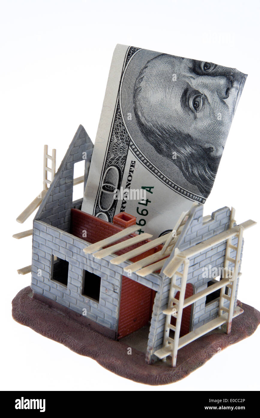 A shell house. Financing with dollar of bank notes, Ein Rohbau Haus. Finanzierung mit Dollar Geldscheinen Stock Photo