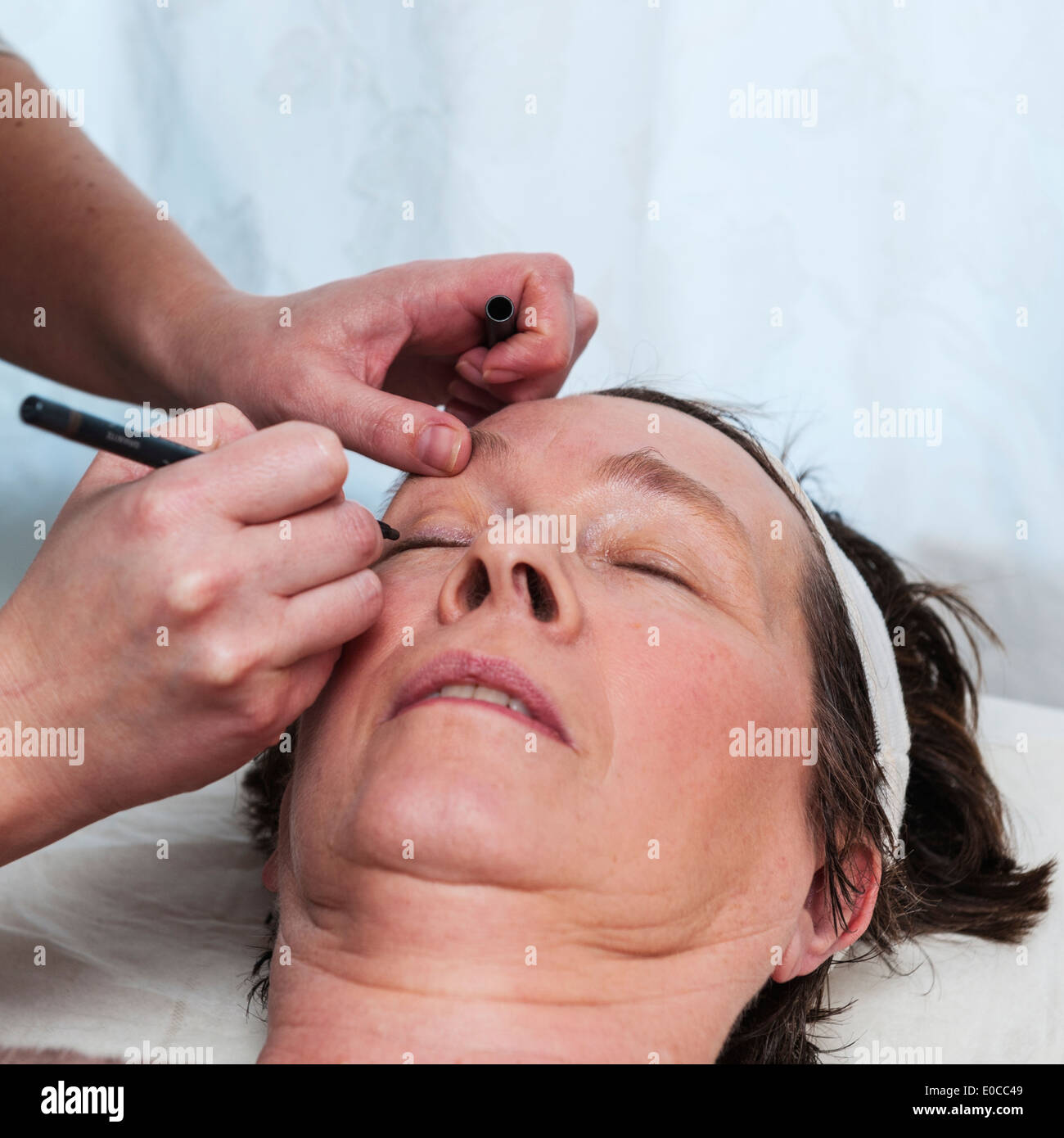 A woman in her early sixties having a facial and make up beauty treatment by a beauty therapist Stock Photo