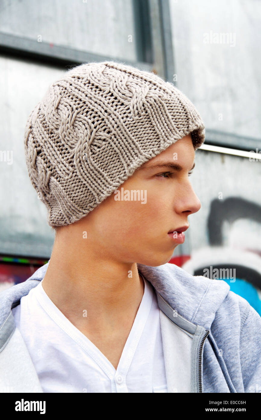 A cool looking youthful man before graffiti, Ein cool blickender Jugendlicher Mann vor Graffiti Stock Photo