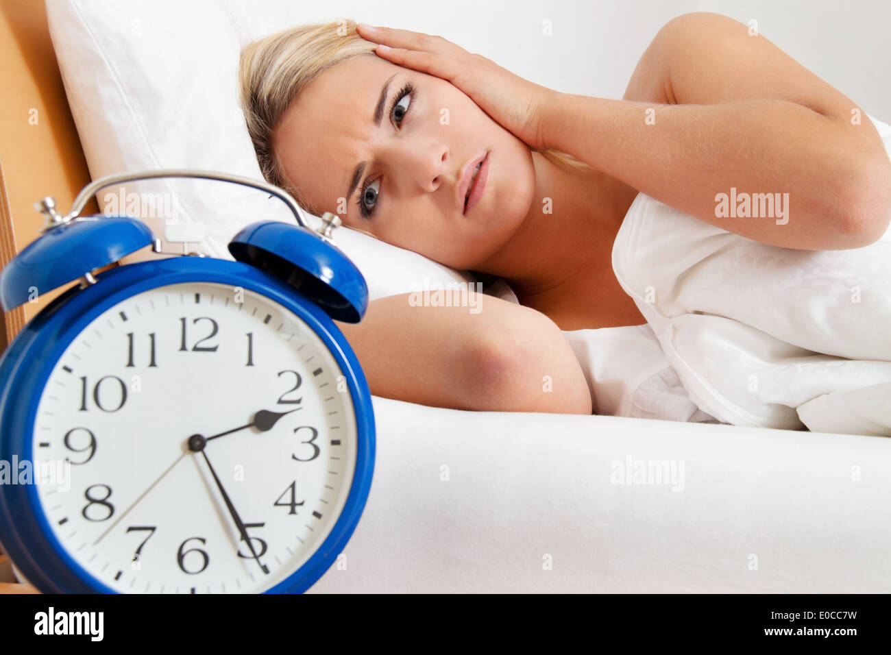 Sleeplessness with clock at night. Woman cannot sleep., Schlaflosigkeit mit Uhr in der Nacht. Frau kann nicht schlafen. Stock Photo