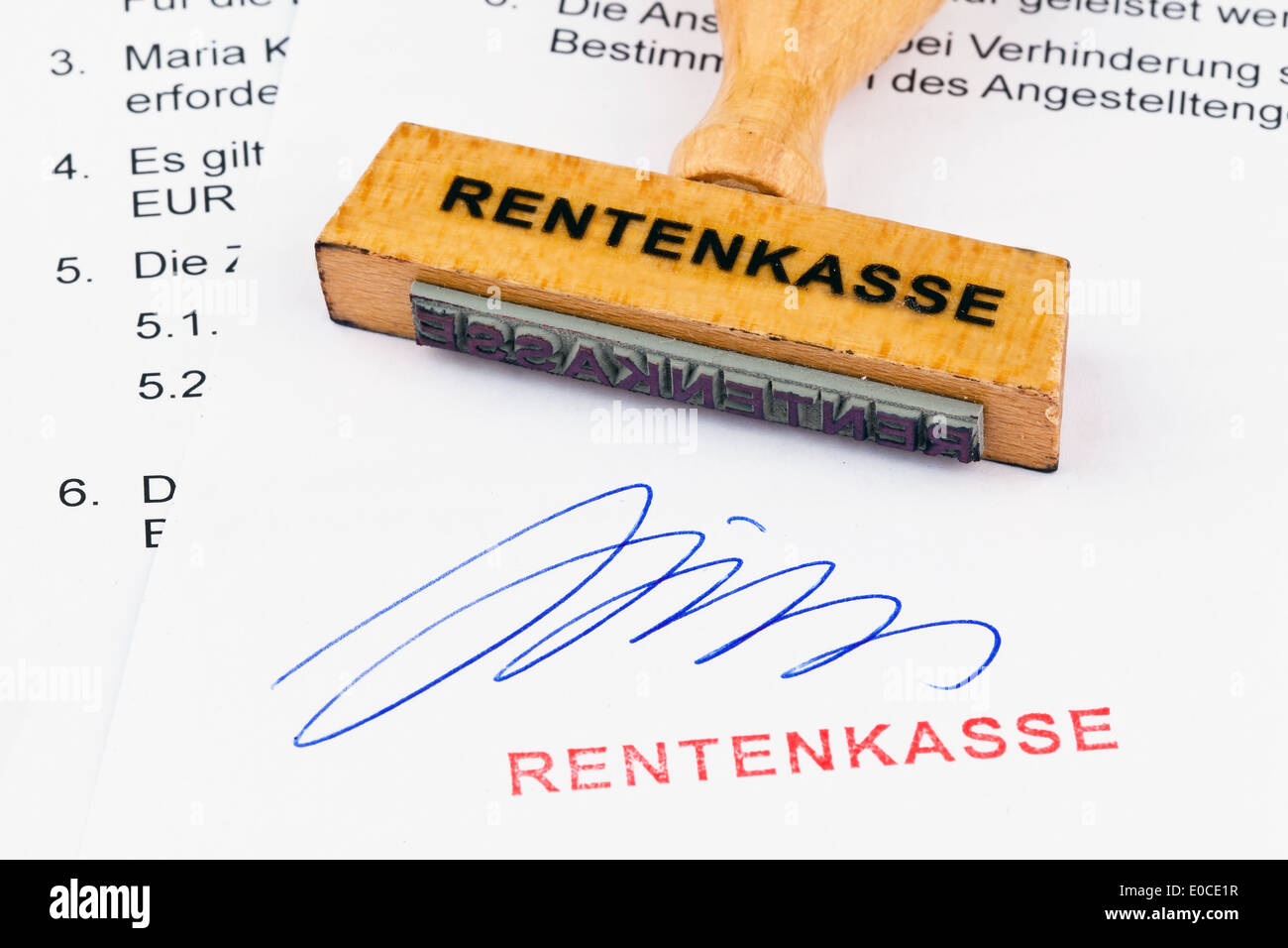 A stamp of wood lies on a document. Label Pension fund, Ein Stempel aus Holz liegt auf einem Dokument. Aufschrift Rentenkasse Stock Photo