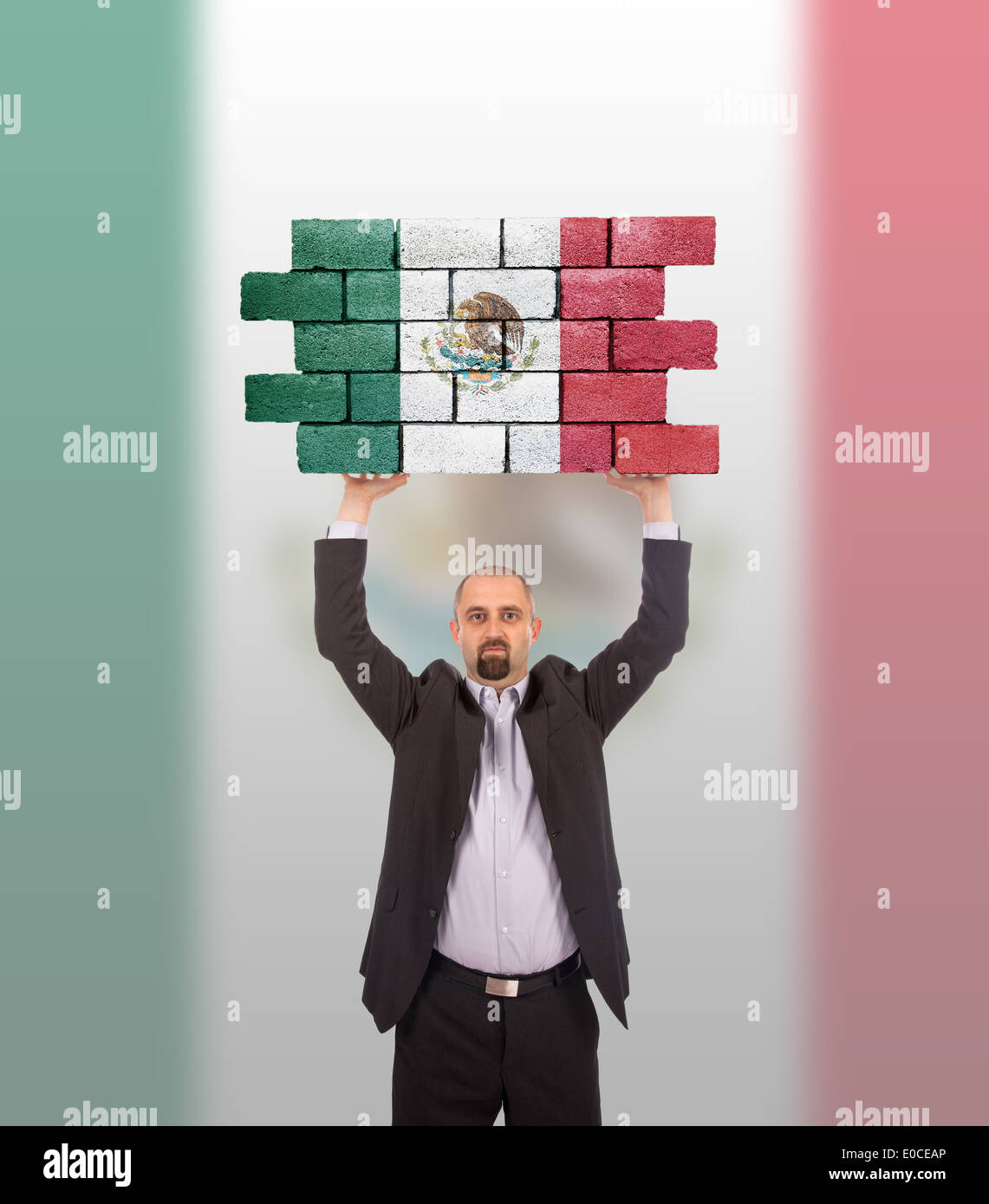 Businessman holding a large piece of a brick wall flag of Mexico ...