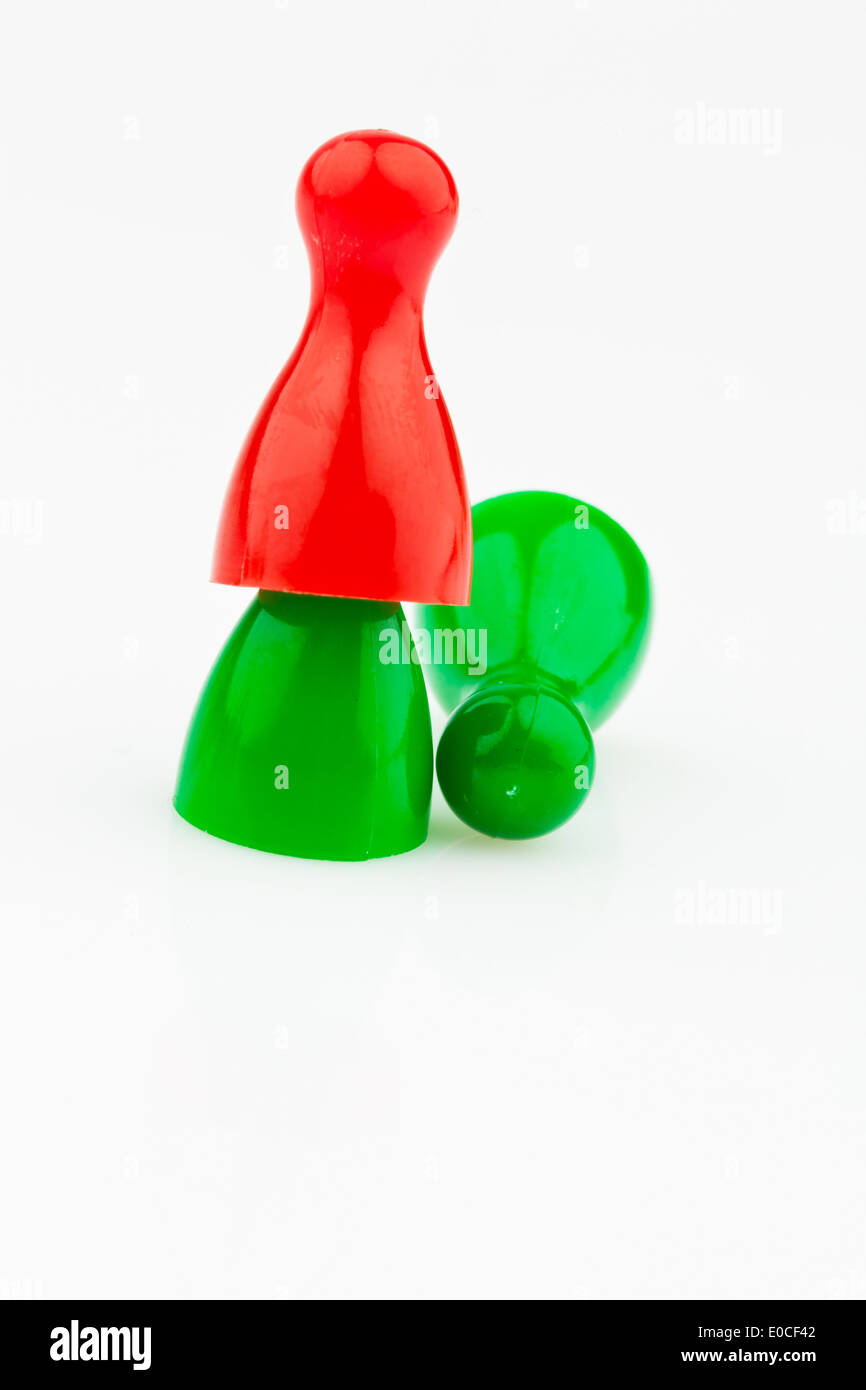 Red and green play figures. Harassment, loneliness and outsider in the team., Rote und gruene Spielfiguren. Mobbing, Einsamkeit Stock Photo