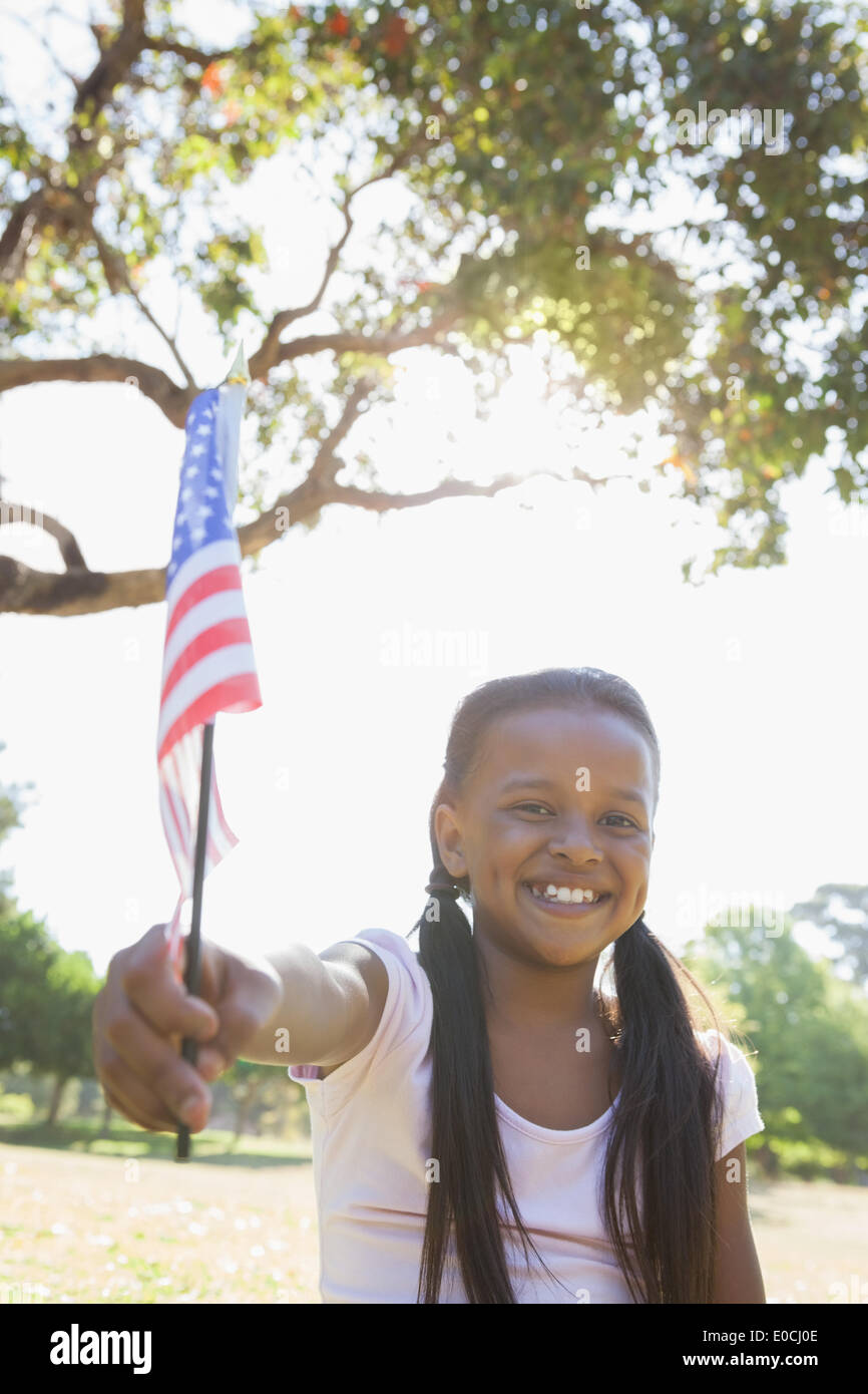 Little girl sitting on grass waving american flag Stock Photo - Alamy