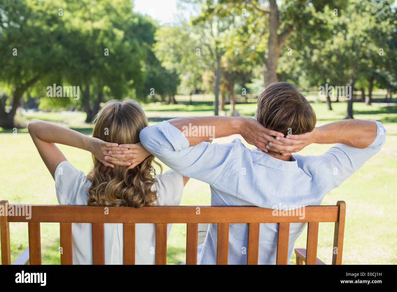 Couple relaxing on park bench together Stock Photo - Alamy