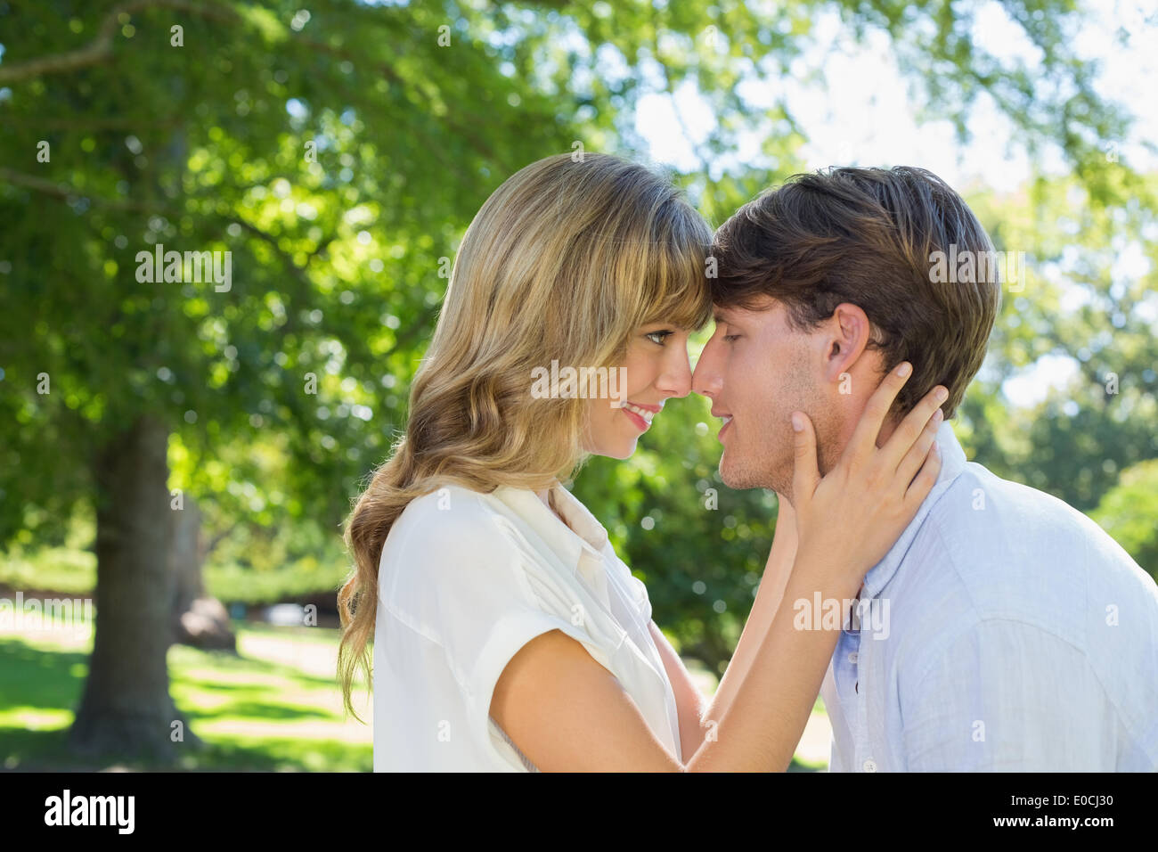 Cute couple hugging and smiling at each other in the park Stock Photo ...