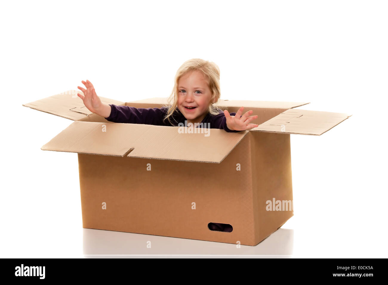 Child in move cardboard. Lies with the move in box., Kind in Umzugskarton. Liegt beim Umzug in Schachtel. Stock Photo