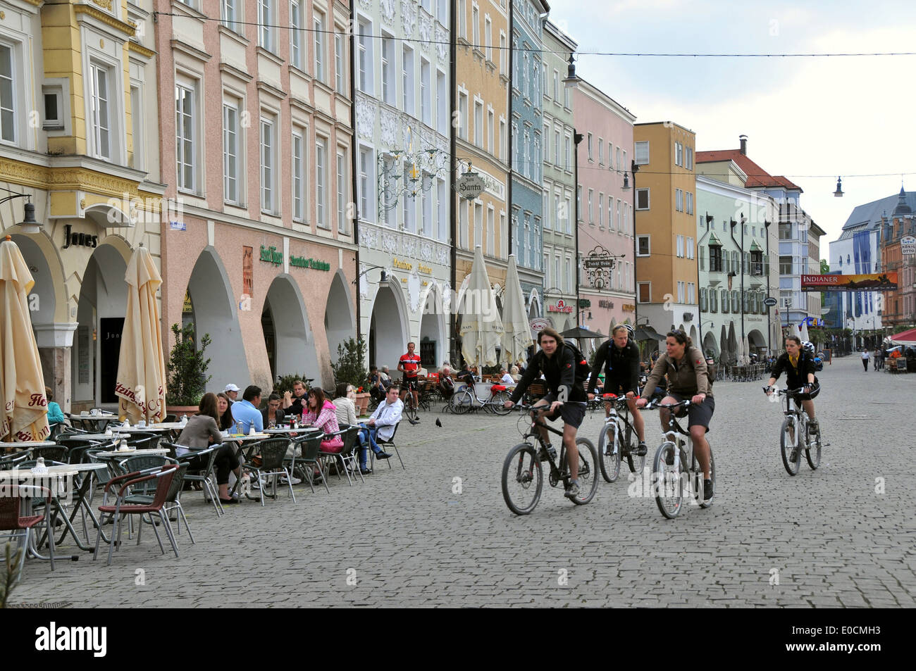 Four cyclists cycling over Max-Joseph-Place, Rosenheim, Bavaria, Germany Stock Photo
