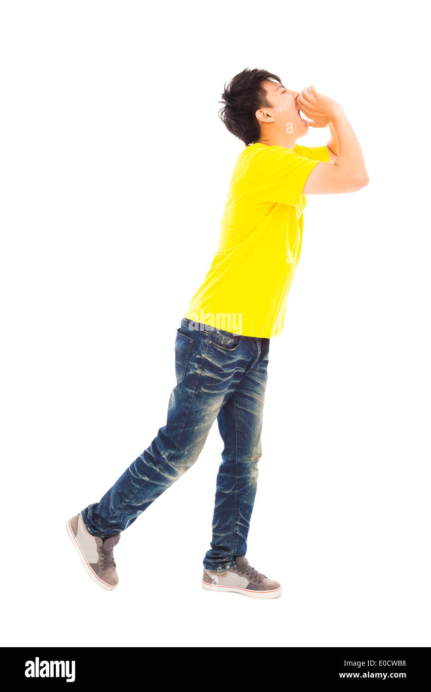 young man walking while raising hands to yell Stock Photo
