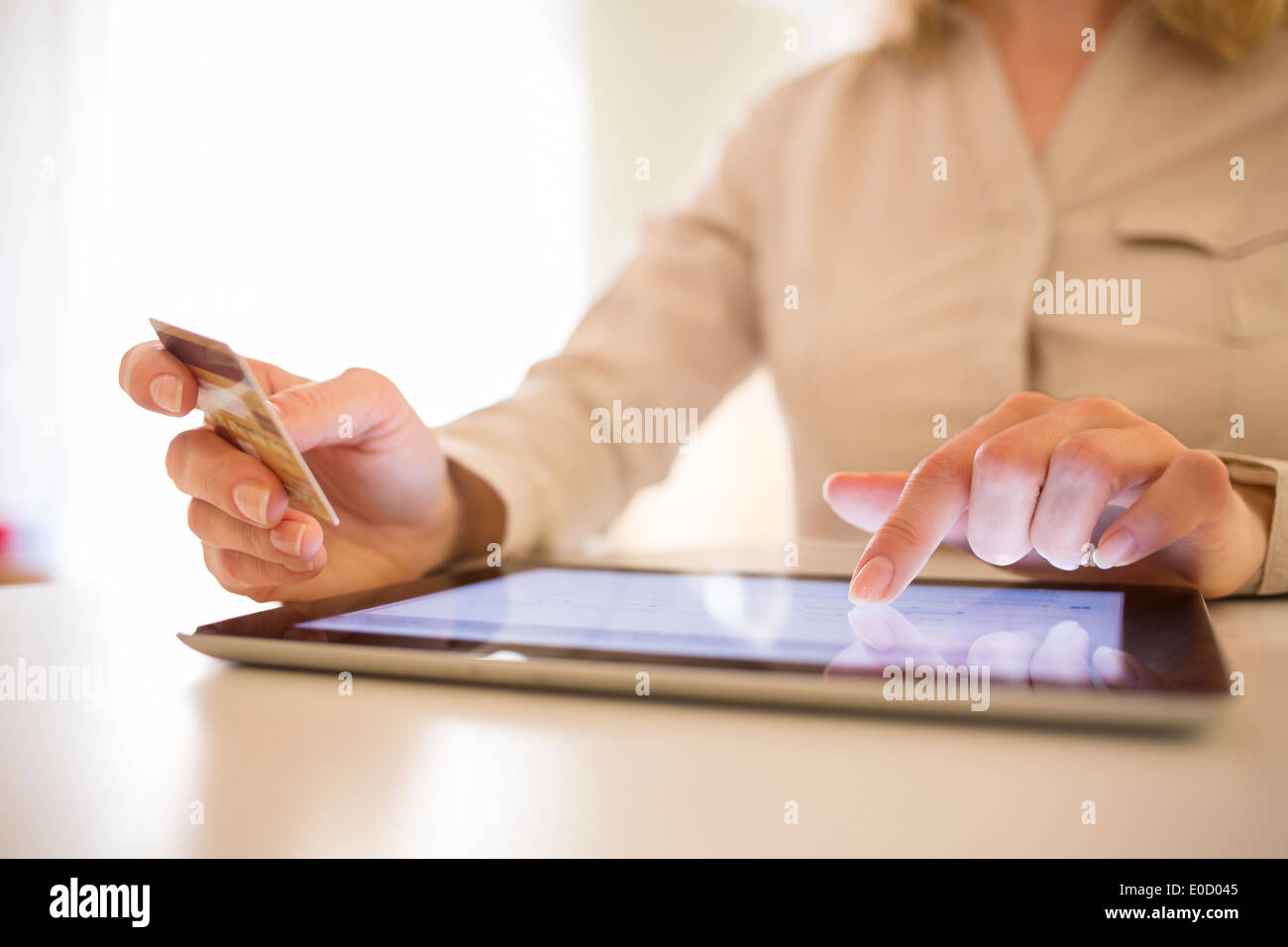 Female plastic card digital computer internet paying house Stock Photo