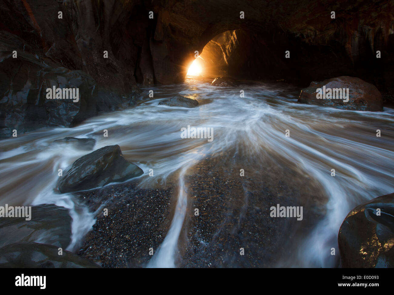 A long exposure blurs a receding wave in a cave, Oregon, USA Stock Photo