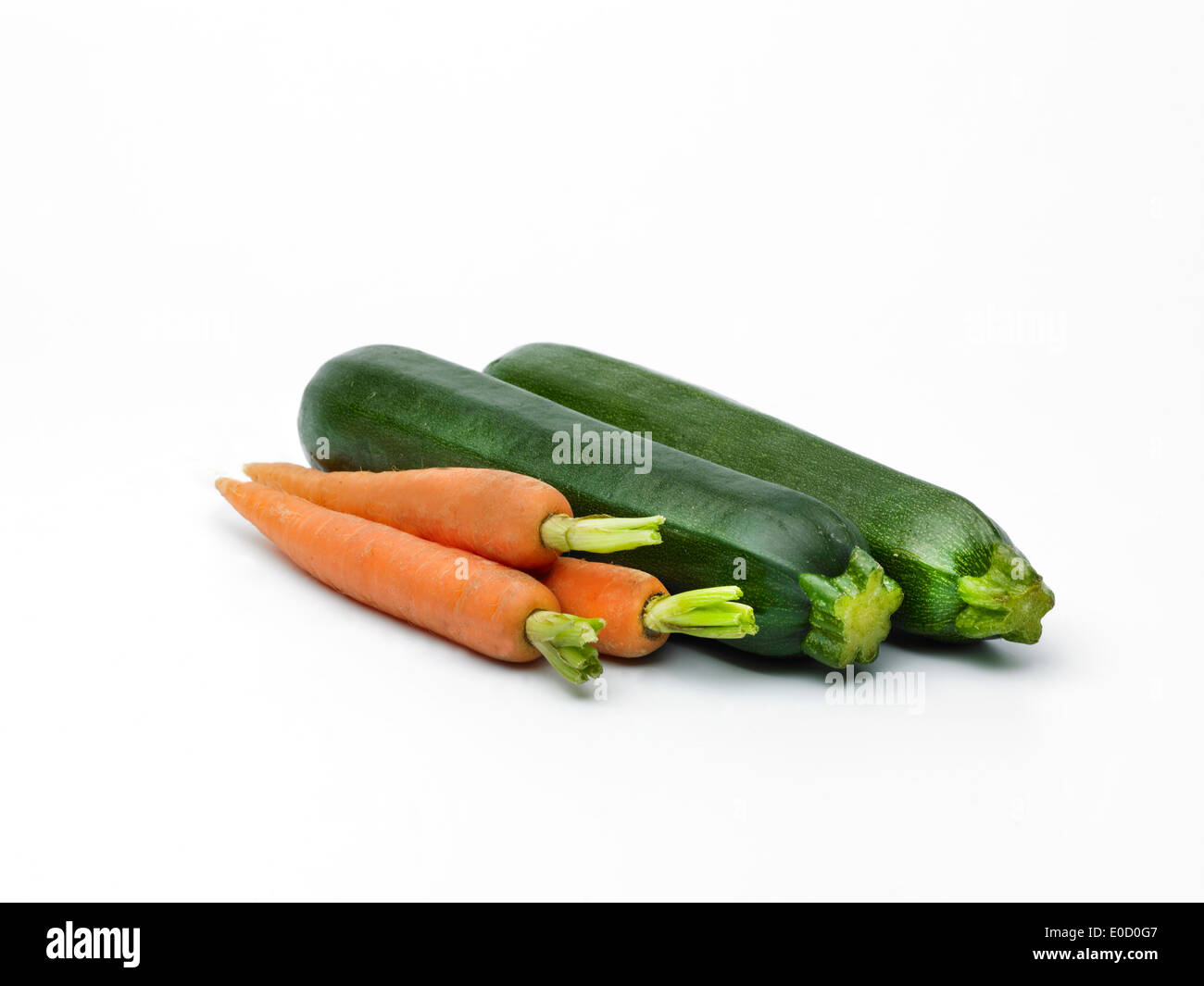 Two courgettes and three carrots on a plain white background Stock Photo