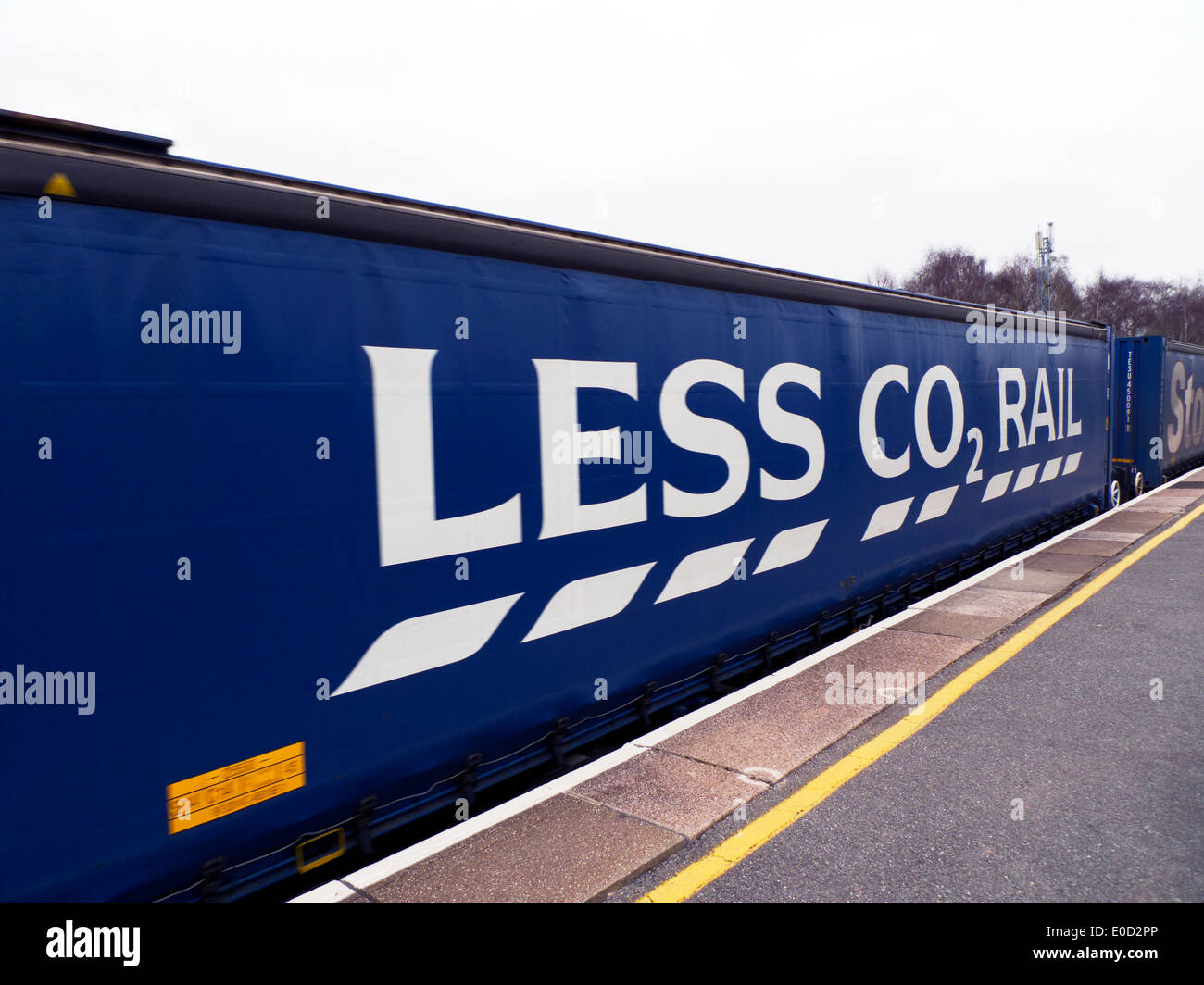 Tesco supermarket 'Less CO2 Rail' environmental advert sign on side of goods train rail freight container in Gloucestershire England UK KATHY DEWITT Stock Photo