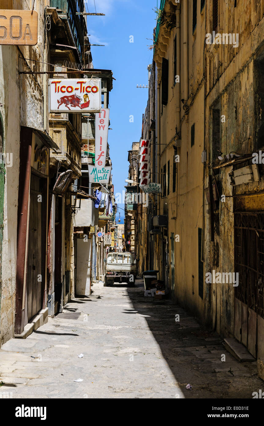A typical narrow street in Valletta bordered by medieval houses and palaces used for modern leisure pursuits. Stock Photo