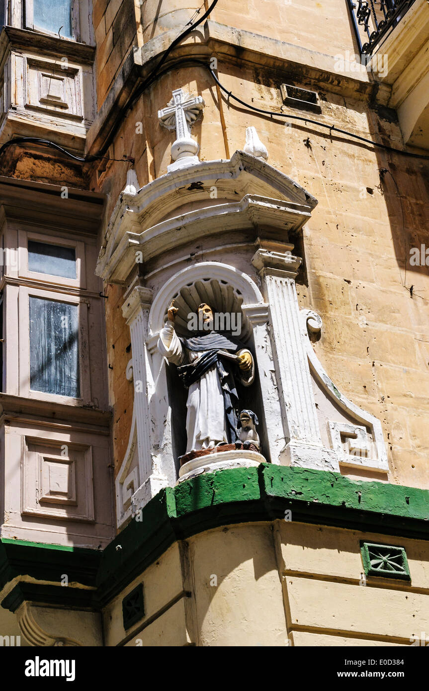 A lifelike statue of Saint Dominic with a dog at his feet preaching