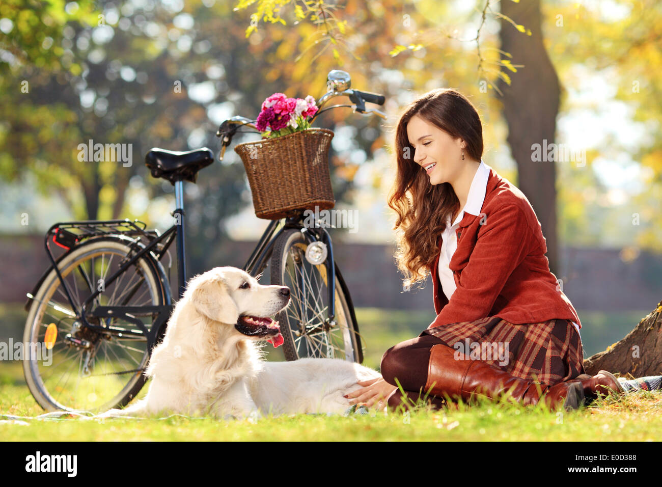 Pretty female sitting down with her dog in a park Stock Photo - Alamy