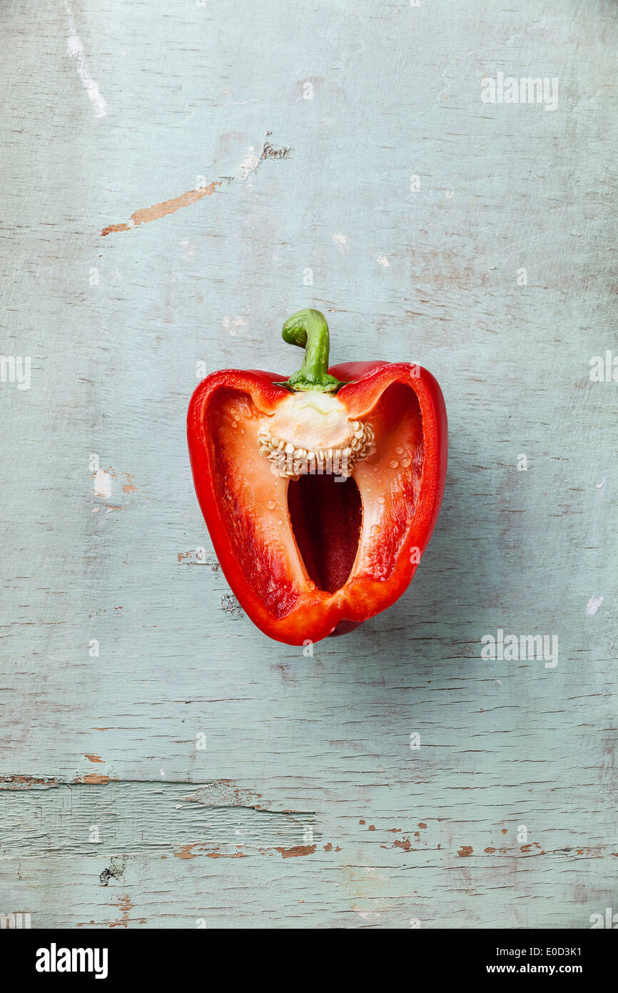 Half red sweet pepper on blue background textural Stock Photo