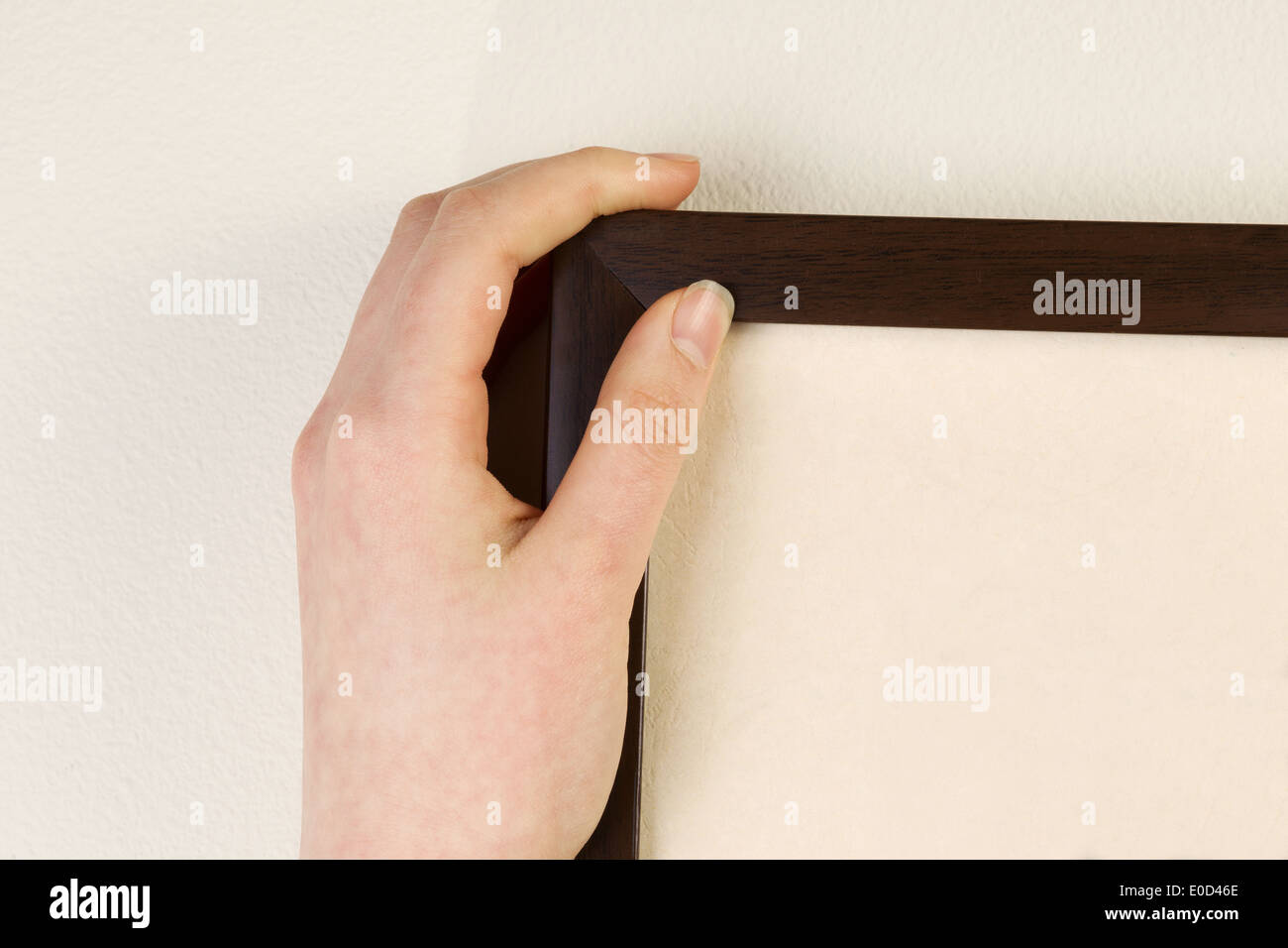 Horizontal photo of female hand holding picture frame against interior