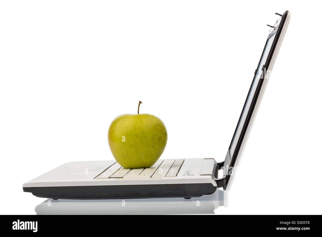 An apple lies on the keyboard of a computer. Symbolic photo for healthy and high vitamin snack., Ein Apfel liegt auf der Tastatu Stock Photo